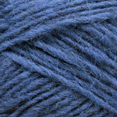 Close-up of Léttlopi (Lite Lopi) Icelandic Wool Yarn by Berroco, Inc. The tightly wound fibers are perfect for colorwork knitting, showcasing various shades of blue with some fine threads and slight fuzziness visible, which gives it a soft texture. The intricate details highlight the twisted strands and durable nature of this exceptional Icelandic wool yarn.