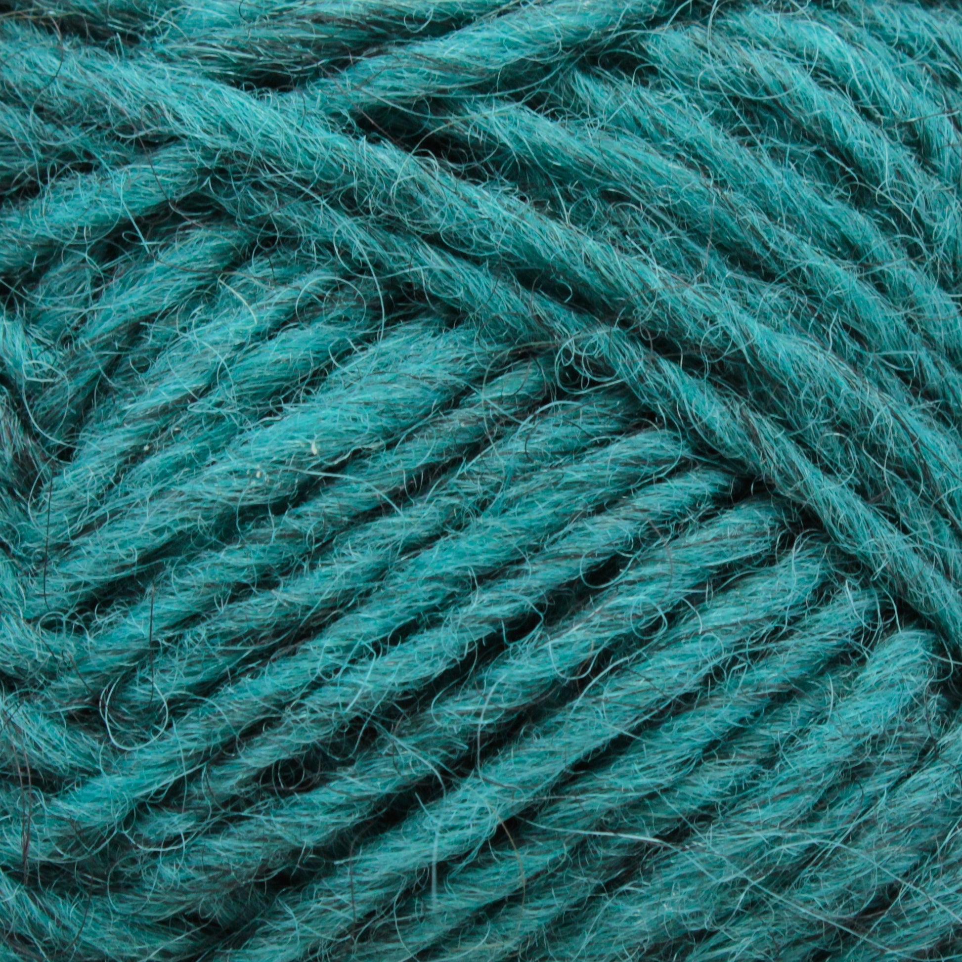 Close-up image of teal-colored yarn from the Léttlopi (Lite Lopi) Icelandic Wool Yarn by Berroco, Inc., showing individual fibers and strands intertwined. The texture is slightly fuzzy, with a consistent thickness throughout. Perfect for colorwork knitting, the image highlights the intricate details and vibrant color of this high-quality wool yarn.