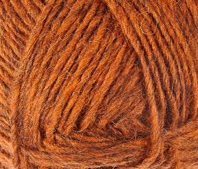 Close-up image of a ball of thick, textured yarn in a rich, warm orange color. The Léttlopi (Lite Lopi) Icelandic Wool Yarn by Berroco, Inc. is neatly wound, displaying the intricate fibers and texture, perfect for durable garments or colorwork knitting.