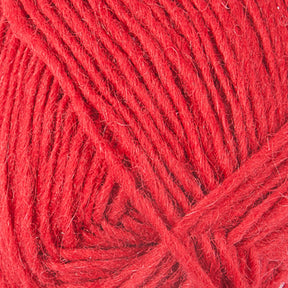 A close-up image of Léttlopi (Lite Lopi) Icelandic Wool Yarn by Berroco, Inc., showcasing the detailed texture and fibers of the yarn strands. The wool is tightly wound, creating a neat and orderly pattern. The vibrant red color is consistent throughout the image, making it perfect for durable garments or intricate colorwork knitting projects.