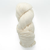 A neatly coiled skein of Henry's Attic's Inca Organic Cotton, featuring off-white, textured yarn against a plain white background. The yarn appears thick and soft, making it ideal for knitting or crocheting projects.