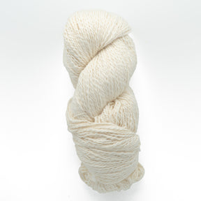 A neatly coiled skein of Henry's Attic's Inca Organic Cotton, featuring off-white, textured yarn against a plain white background. The yarn appears thick and soft, making it ideal for knitting or crocheting projects.