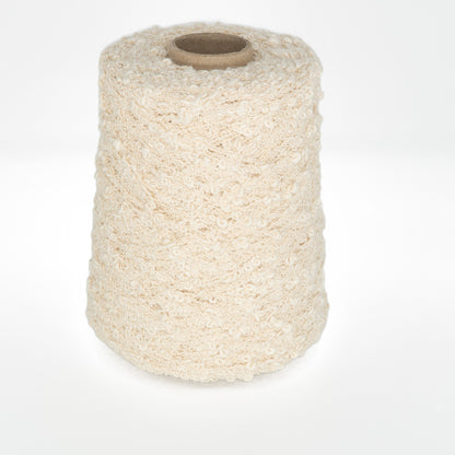 A cylindrical spool of Henry's Attic Cathy - Cotton Yarn in a cream color is standing upright against a white background. The yarn features a bumpy, curly texture, resembling boucle or a similar type, ideal for crafting intricate lace patterns with varying textures when knitting or weaving.