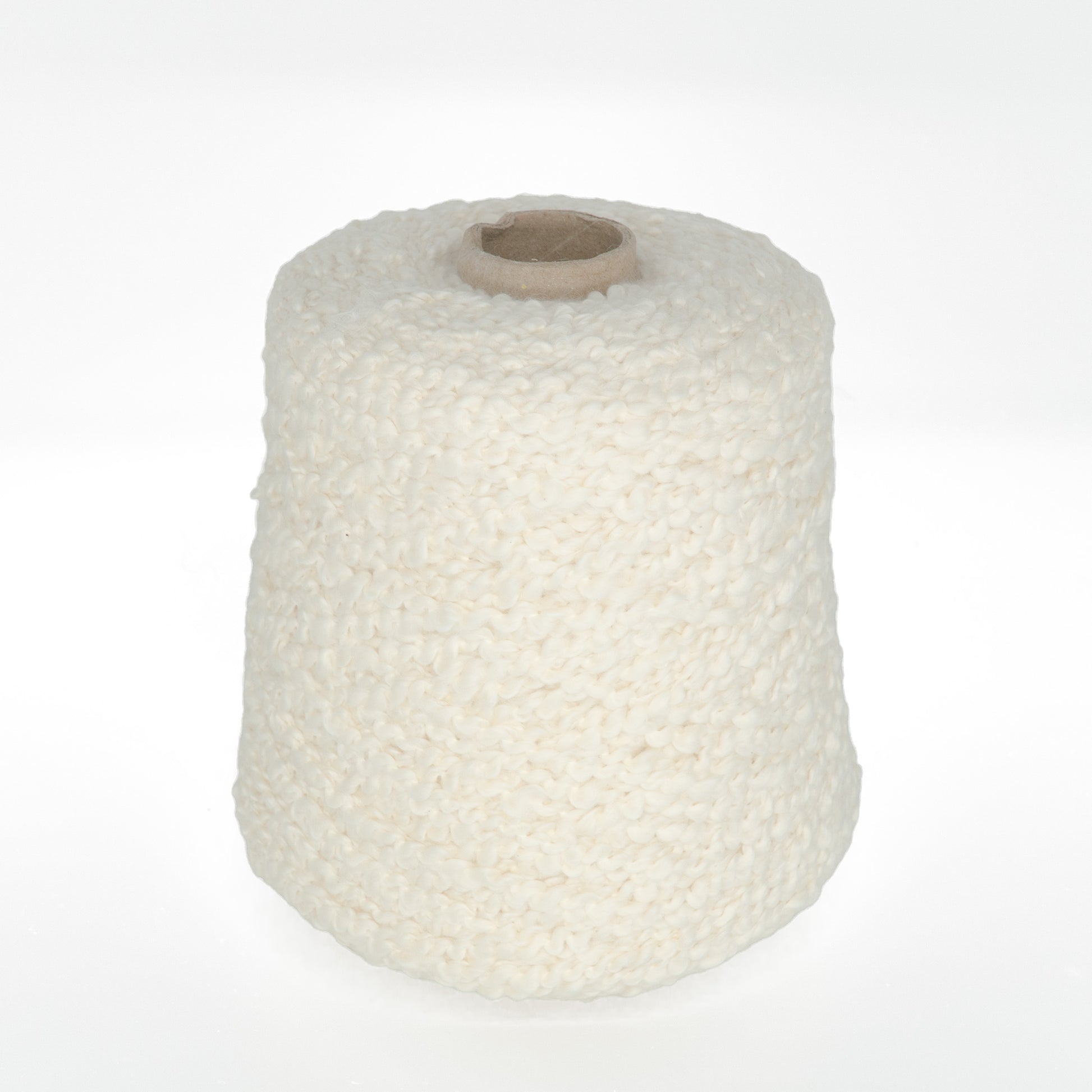 A large spool of Tess Cotton Yarn from Henry's Attic, in an off-white and textured style, is centered against a plain white background. The yarn appears to be thick and plush, making it perfect for knitting and crochet projects like warm baby blankets.