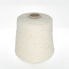 A large spool of Tess Cotton Yarn from Henry's Attic, in an off-white and textured style, is centered against a plain white background. The yarn appears to be thick and plush, making it perfect for knitting and crochet projects like warm baby blankets.