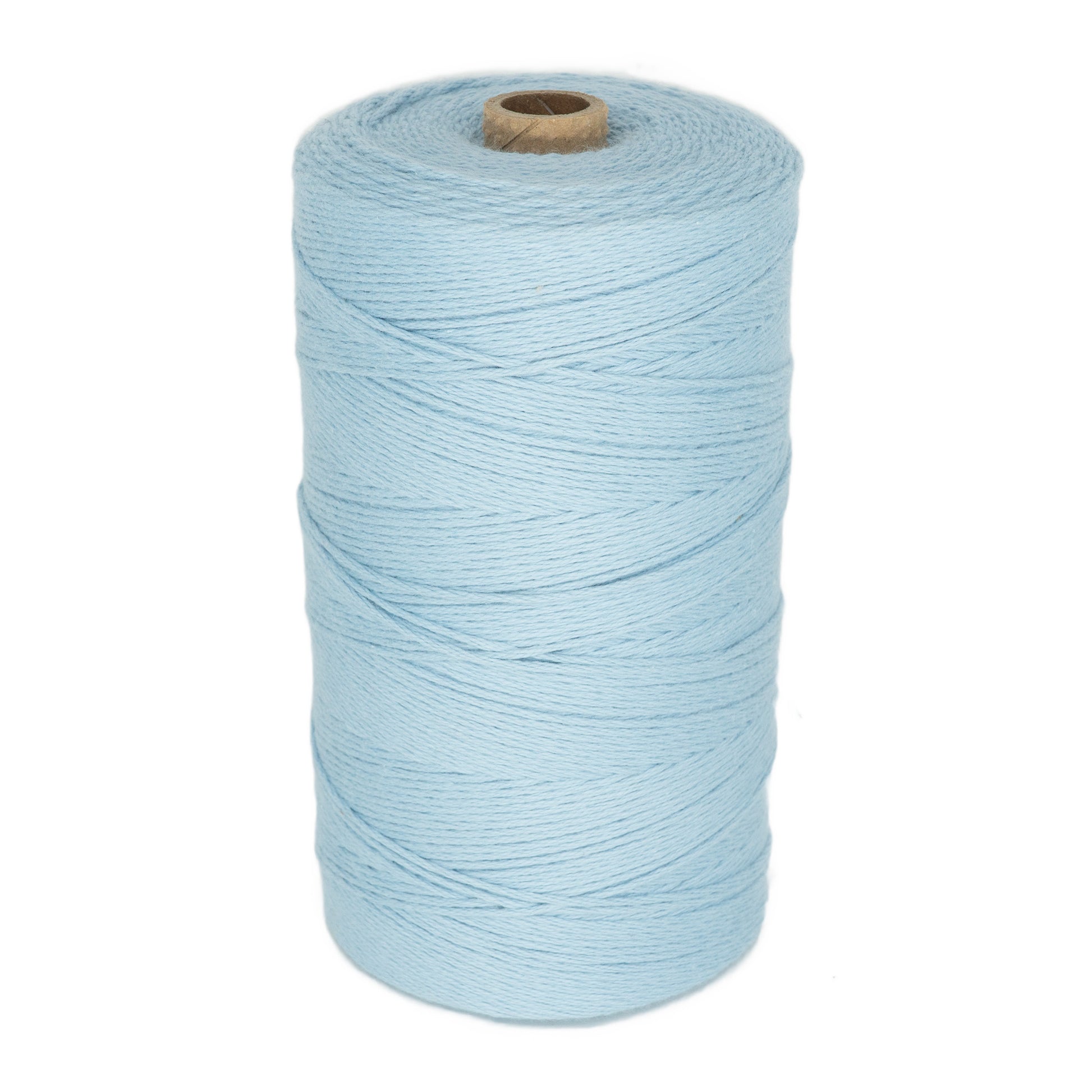 A large spool of light blue Maurice Brassard Cotton 8/8 Carpet Warp, ideal for knitting and crochet, is shown in an upright position. The unmercerized cotton yarn is neatly wound around a cylindrical core made of brown cardboard. The texture of the yarn appears soft and slightly twisted.