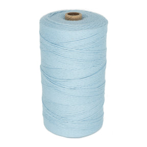 A large spool of light blue Maurice Brassard Cotton 8/8 Carpet Warp, ideal for knitting and crochet, is shown in an upright position. The unmercerized cotton yarn is neatly wound around a cylindrical core made of brown cardboard. The texture of the yarn appears soft and slightly twisted.