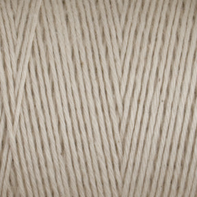 Close-up image of Great Northern Weaving’s Cotton Carpet Warp 8/4 in beige. The detailed texture reveals tightly spun fibers with a slightly uneven, natural look. The color is a soft, neutral beige with subtle tonal variations, providing a warm and cozy feel ideal for knitting or crocheting projects such as cozy coverlets.