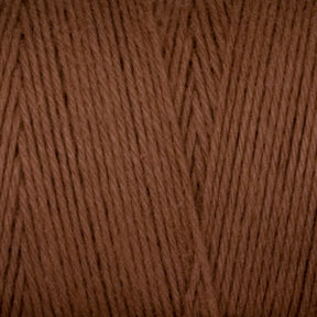 Close-up image of Cotton Carpet Warp 8/4 by Great Northern Weaving, revealing a detailed texture with individual strands expertly twisted together. The yarn appears soft and is tightly wound, making it perfect for knitting or crocheting projects such as cozy coverlets or durable rag rugs.