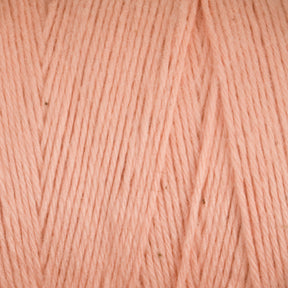 Close-up image of a soft, pastel peach-colored Cotton Carpet Warp 8/4 by Great Northern Weaving. The fibers are tightly twisted, creating a smooth, consistent texture perfect for crafting delicate cotton warp coverlets. The color appears uniform throughout the yarn, and the surface shows fine details of the strands.