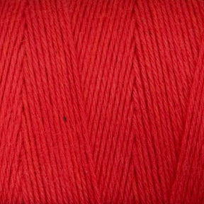 Close-up of Great Northern Weaving's Cotton Carpet Warp 8/4 in red, revealing the detailed texture and individual strands tightly wound together. The yarn appears to be soft and evenly colored throughout, ideal for knitting or crocheting projects like rag rugs or coverlets.