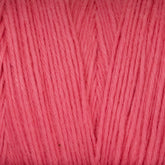 Close-up of a skein of Great Northern Weaving's Cotton Carpet Warp 8/4 in bright pink. The texture of the yarn is clearly visible, with fibers running vertically and slightly intertwining. The surface appears soft and smooth, making it ideal for knitting or crocheting coverlets.