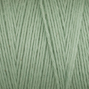 Close-up image of Great Northern Weaving's Cotton Carpet Warp 8/4 in light green, showcasing neatly wound strands. The soft and smooth texture is evident, with tightly twisted fibers forming a consistent pattern ideal for knitting, crocheting, or weaving coverlets.