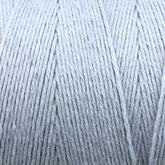 Close-up image of the Great Northern Weaving Cotton Carpet Warp 8/4 in gray, tightly wound into a spool. The yarn's texture and individual strands are clearly visible, highlighting the fine, soft threads—perfect for creating intricate coverlets.