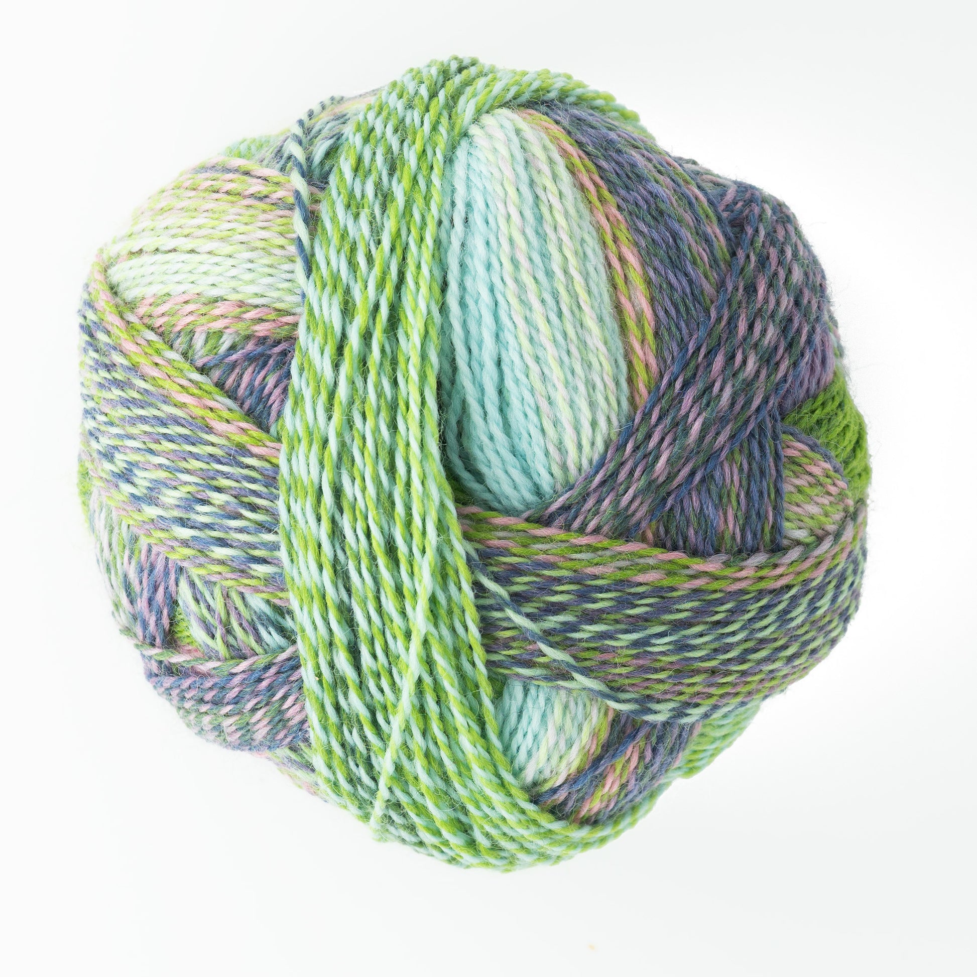 Close-up of the Skacel Zauberball Crazy Sock Yarn, showcasing a vibrant blend of green, blue, purple, and white threads. The yarn is tightly wound, creating a textured and intricate appearance that stands out against a plain white background.