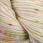 Close-up image of Plymouth Yarn Co.'s Happy Feet Sock Yarn, showcasing a skein of durable knitting yarn in creamy white with colorful speckles, including shades of yellow, green, and pink. The thick, twisted texture reveals subtle variations in its superwash Merino wool fibers.