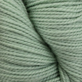 Close-up of mint green Happy Feet Sock Yarn by Plymouth Yarn Co. coiled into a skein. The texture of this superwash Merino wool is visible, showing soft fibers and a smooth, tightly twisted appearance. Perfect for durable knitting projects.