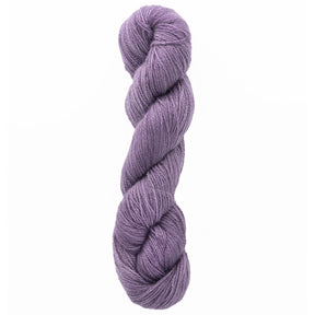 A twisted skein of Jade Sapphire Cashmere 2-Ply yarn from Jade Sapphire Exotic Fibres, coiled elegantly, offers a smooth, thick texture. Perfect for lacy scarves and accessories, its soft purple hue resembles gentle lavender, reminiscent of hand-dyed colors.