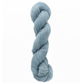 A skein of Jade Sapphire Cashmere 2-Ply yarn from Jade Sapphire Exotic Fibres, in light blue, perfect for crafting lacy scarves, is coiled neatly against a plain white background.