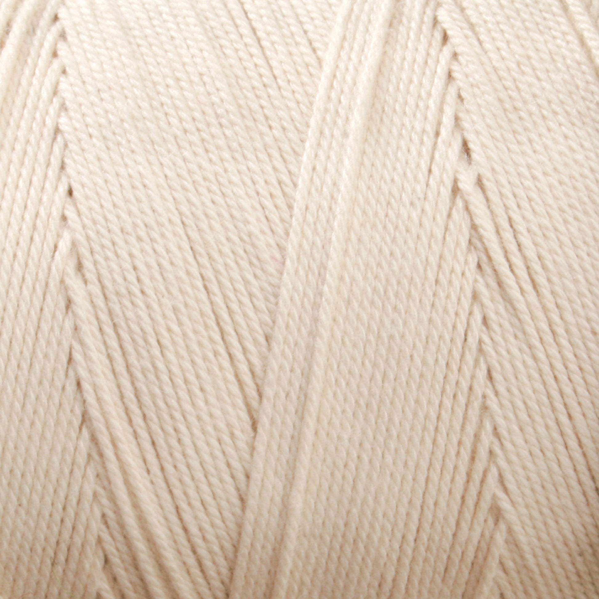 Close-up view of a tightly wound, cream-colored spool of Glimakra's Swedish Cotton Warp (Seine Twine, Fiskgarn). The texture of the fibers is visible, showcasing the intricate pattern of the cotton warp yarns' strands. The yarn appears smooth and evenly wound around the spool.