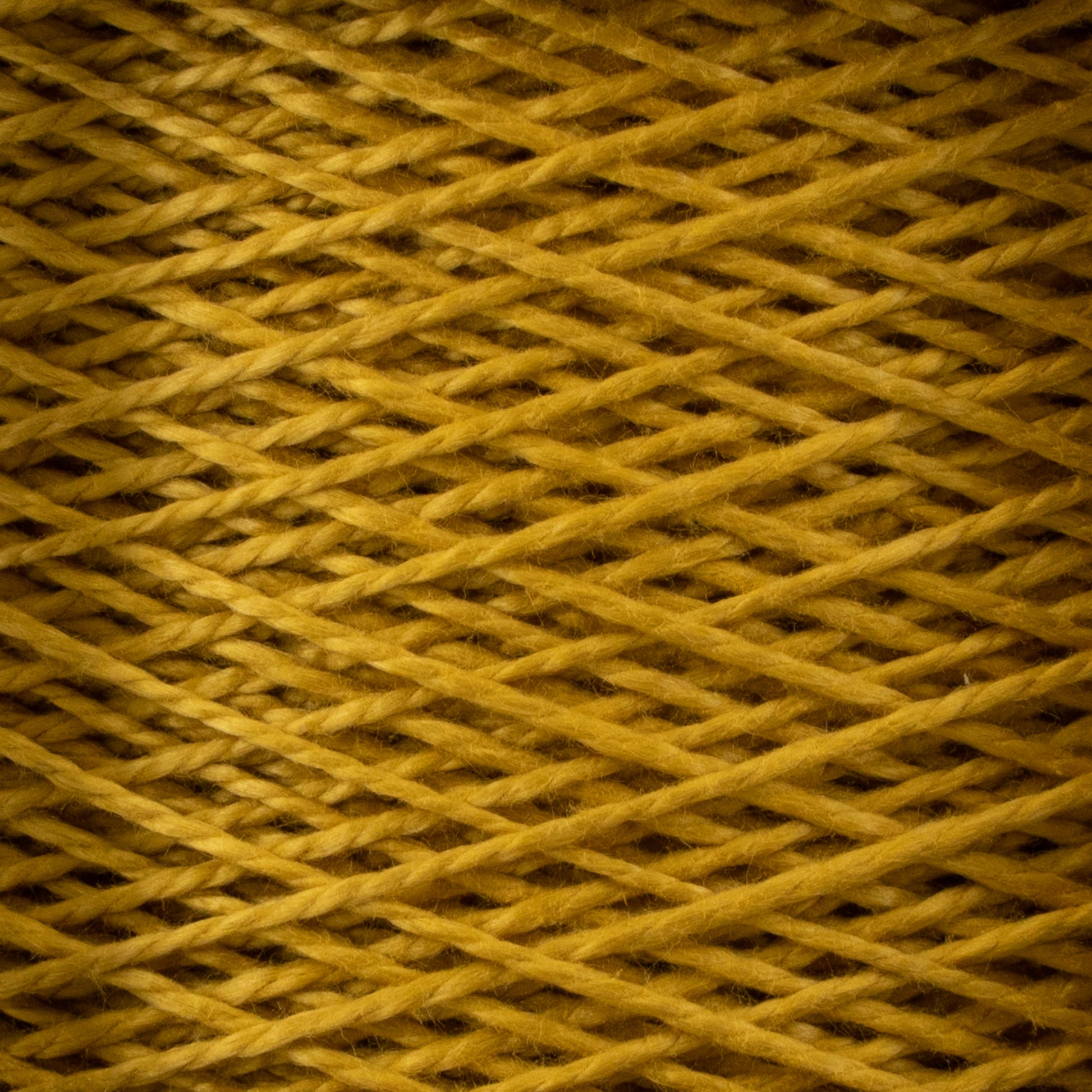 A close-up image of tightly wound 3/2 Pearl Cotton Yarn | Mini-cone by Supreme Corp in a vibrant yellow color. The strands of the yarn are crisscrossed in a detailed, repeating pattern, creating a textured appearance. The photo captures the intricate lines and fibrous texture of this versatile pearl cotton yarn.