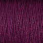 Close-up view of a skein of Supreme Corp's 3/2 Pearl Cotton Yarn on a large cone, showcasing its rich, deep purple hue. The yarn is tightly wound in neat, parallel rows, displaying a soft and slightly glossy texture. Individual strands of the versatile yarn are clearly visible.