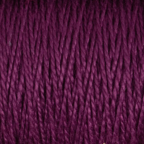 Close-up view of a skein of Supreme Corp's 3/2 Pearl Cotton Yarn on a large cone, showcasing its rich, deep purple hue. The yarn is tightly wound in neat, parallel rows, displaying a soft and slightly glossy texture. Individual strands of the versatile yarn are clearly visible.