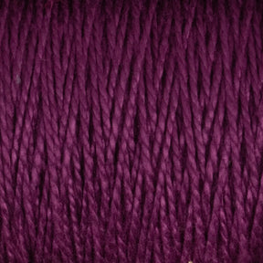 Experience a close-up view of the 3/2 Pearl Cotton Yarn | Mini-cone by Supreme Corp, showcasing its twisted strands of deep purple, mercerized cotton yarn. The texture is clearly visible, revealing tightly wound fibers with a slight sheen. The rich, vibrant color accentuates the pattern and intricacy of each individual strand.