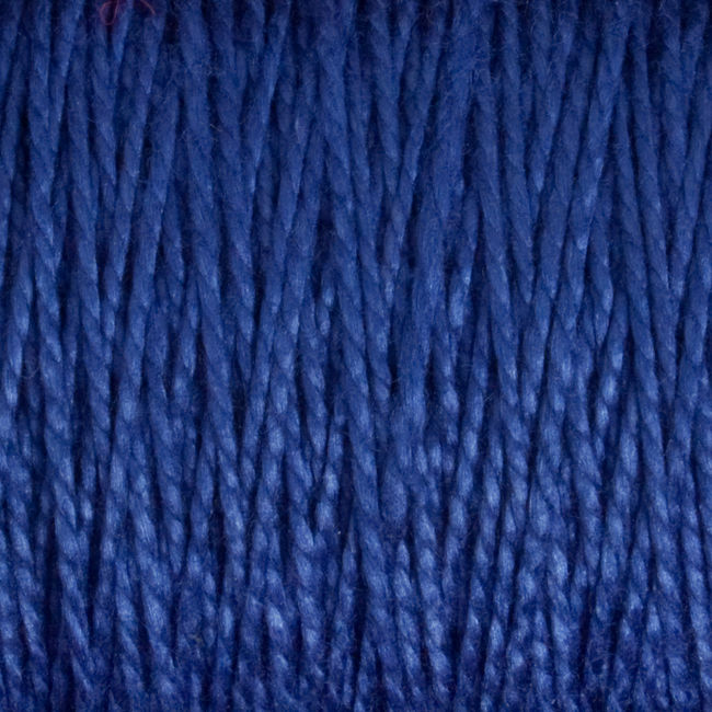 Close-up of several strands of 3/2 Pearl Cotton Yarn | Large Cone by Supreme Corp in dark blue. The texture is beautifully visible, showcasing individual twisted threads. The background is entirely filled with the yarn, emphasizing its rich color and detailed fiber structure.