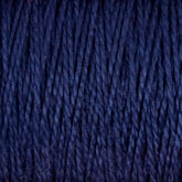 Close-up of tightly wound 3/2 Pearl Cotton Yarn from Supreme Corp, showcasing its textured, fibrous strands. This versatile mini-cone yarn appears soft and thick, with a rich, dark blue color that is consistent throughout.