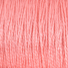 Close-up image of 3/2 Pearl Cotton Yarn fibers from Supreme Corp, tightly wound together on a large cone. The pink yarn showcases its texture and intricate threading, appearing smooth and uniform with an even distribution of color.