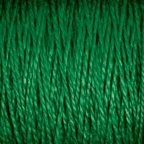 Close-up of Supreme Corp’s 3/2 Pearl Cotton Yarn | Large Cone, showcasing green mercerized cotton strands tightly packed together, creating a textured surface. The uniformly colored strands exhibit a somewhat shiny and smooth texture. The image emphasizes the intricate details and fibers of this versatile yarn.