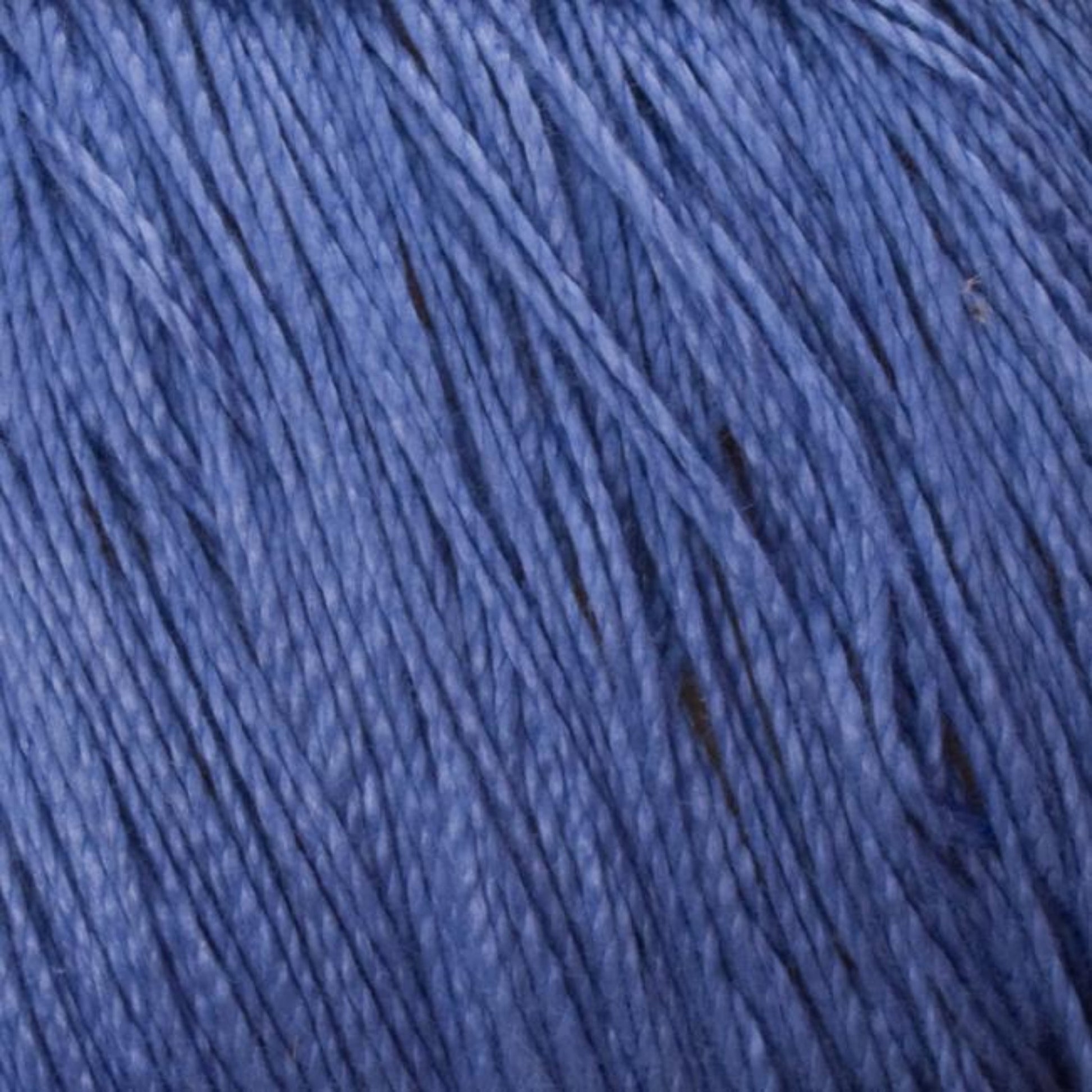 Close-up image of Supreme Corp's 3/2 Pearl Cotton Yarn in soft blue, tightly wound together. The texture appears smooth and fine, with a uniform color throughout. The strands lie neatly, showcasing the delicate and consistent nature of this versatile yarn available in a large cone.