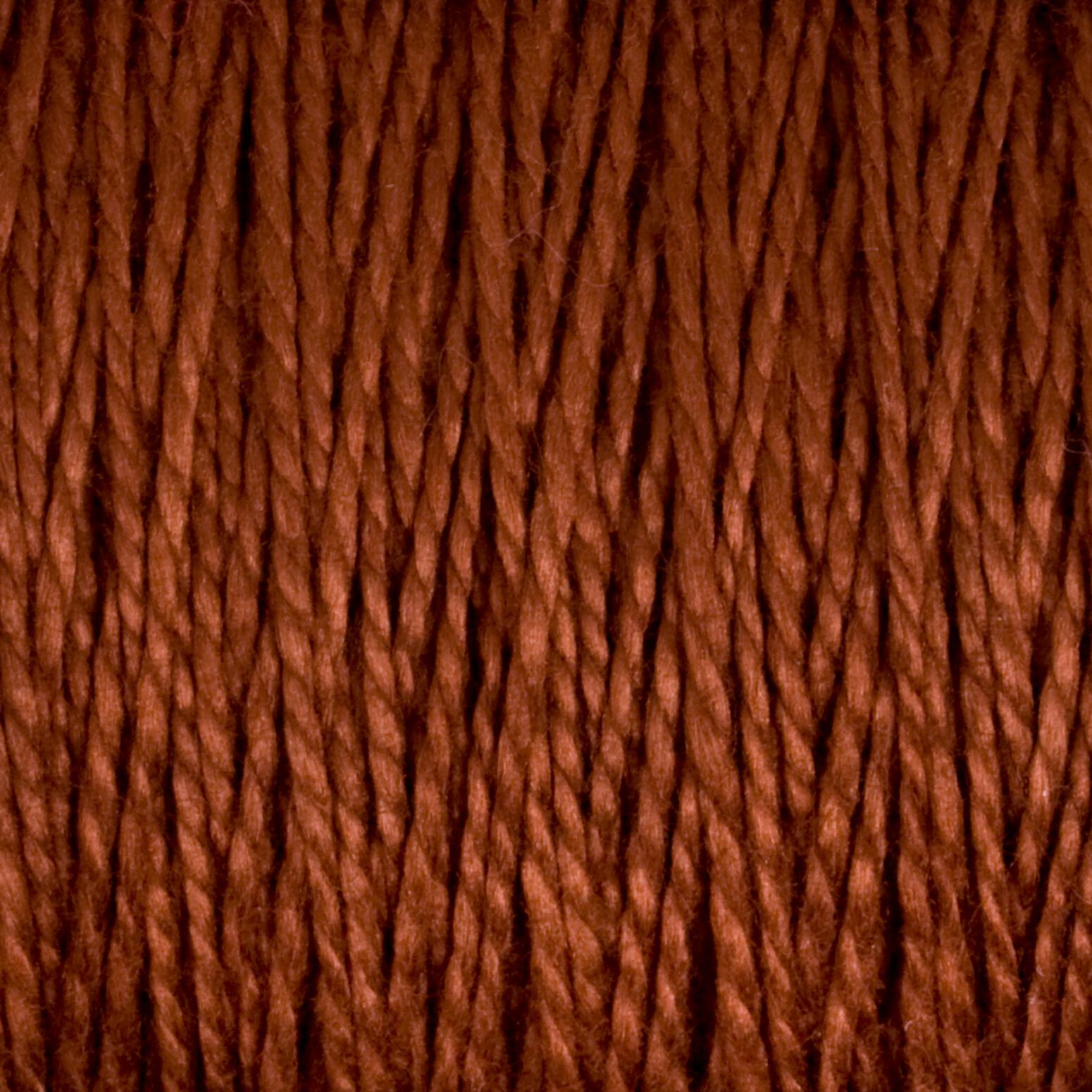 Close-up of a textured surface showing tightly wound, thick strands of brown 5/2 Pearl Cotton Yarn by Supreme Corp. The fibers twist and intertwine, creating a dense and prominent pattern. The lighting highlights the texture and depth of the versatile yarn from the Large Cone, reminiscent of finely spun Pearl Cotton.