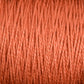 Close-up image of a spool of tightly wound, reddish-brown 5/2 Pearl Cotton Yarn from Supreme Corp. The texture is clearly visible, with individual fibers creating a slightly rough, yet uniform appearance. The warm and earthy hue makes it perfect for weaving projects.