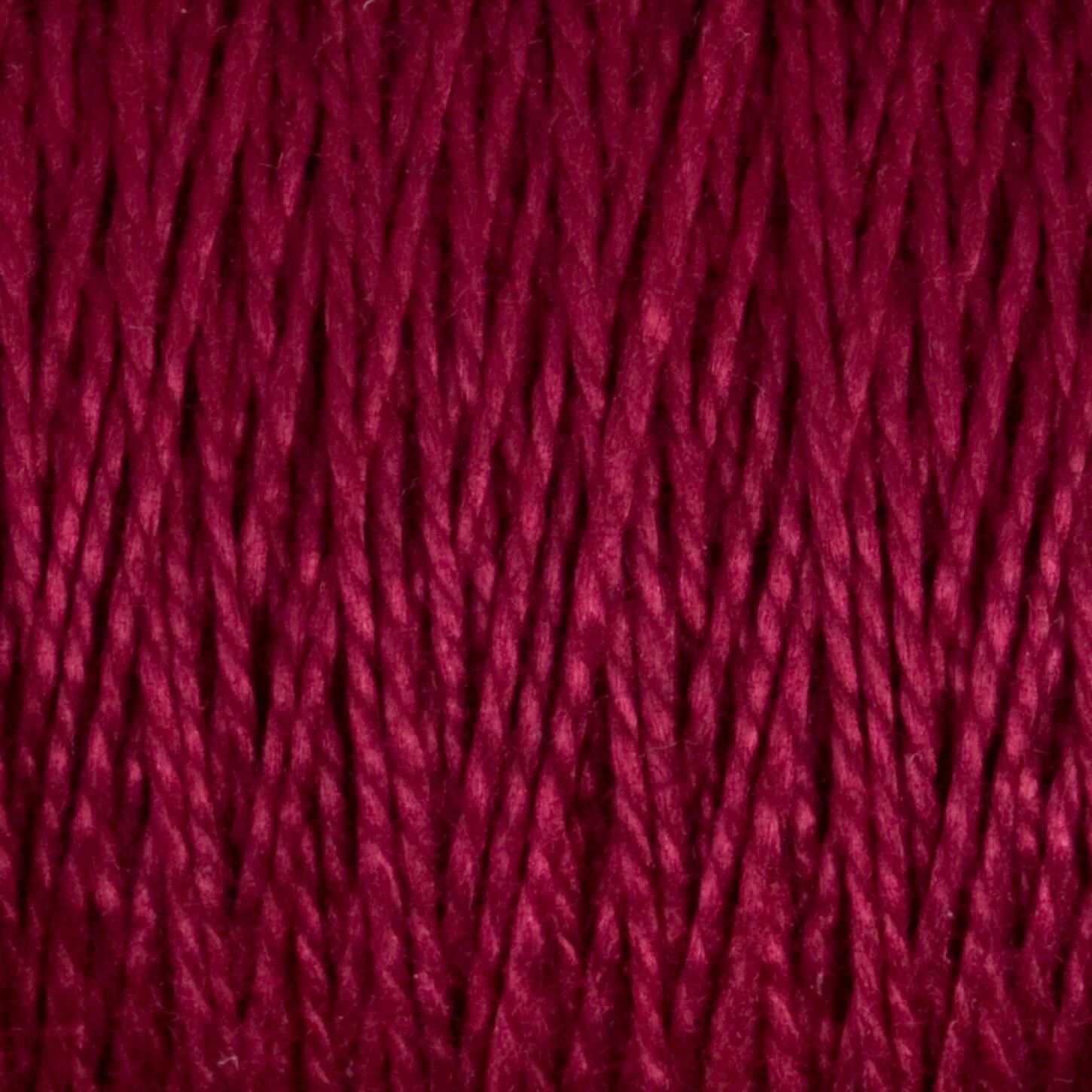 Close-up image of thick, red 5/2 Pearl Cotton Yarn from Supreme Corp, tightly wound in a parallel pattern on a large cone. The yarn has a rich, deep color and a slightly shiny texture, revealing individual twisted strands that provide a sense of both warmth and softness.