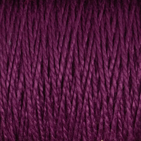 Close-up view of a purple skein of Supreme Corp's 5/2 Pearl Cotton Yarn | Large Cone, showcasing its tightly wound, fibrous texture and rich color. The strands are neatly aligned, emphasizing the material's smooth and soft appearance.