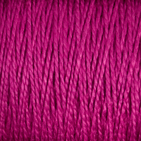 Close-up image of the rich, magenta-colored 5/2 Pearl Cotton Yarn from Supreme Corp, showcasing its mercerized cotton fibers intricately twisted together. The texture appears thick and soft, highlighting the detailed strands interwoven to create a dense fabric. Perfect for weaving projects, this vibrant hue adds a lively and warm feel to the material.