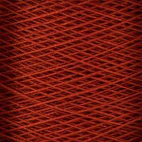 Close-up image of a large cone of red 10/2 Pearl Cotton Yarn by Supreme Corp., showcasing the fine texture and overlapping pattern of the tightly wound fibers. The image reveals a uniform and intricate crisscross design, highlighting the smooth and consistent appearance of this versatile yarn.