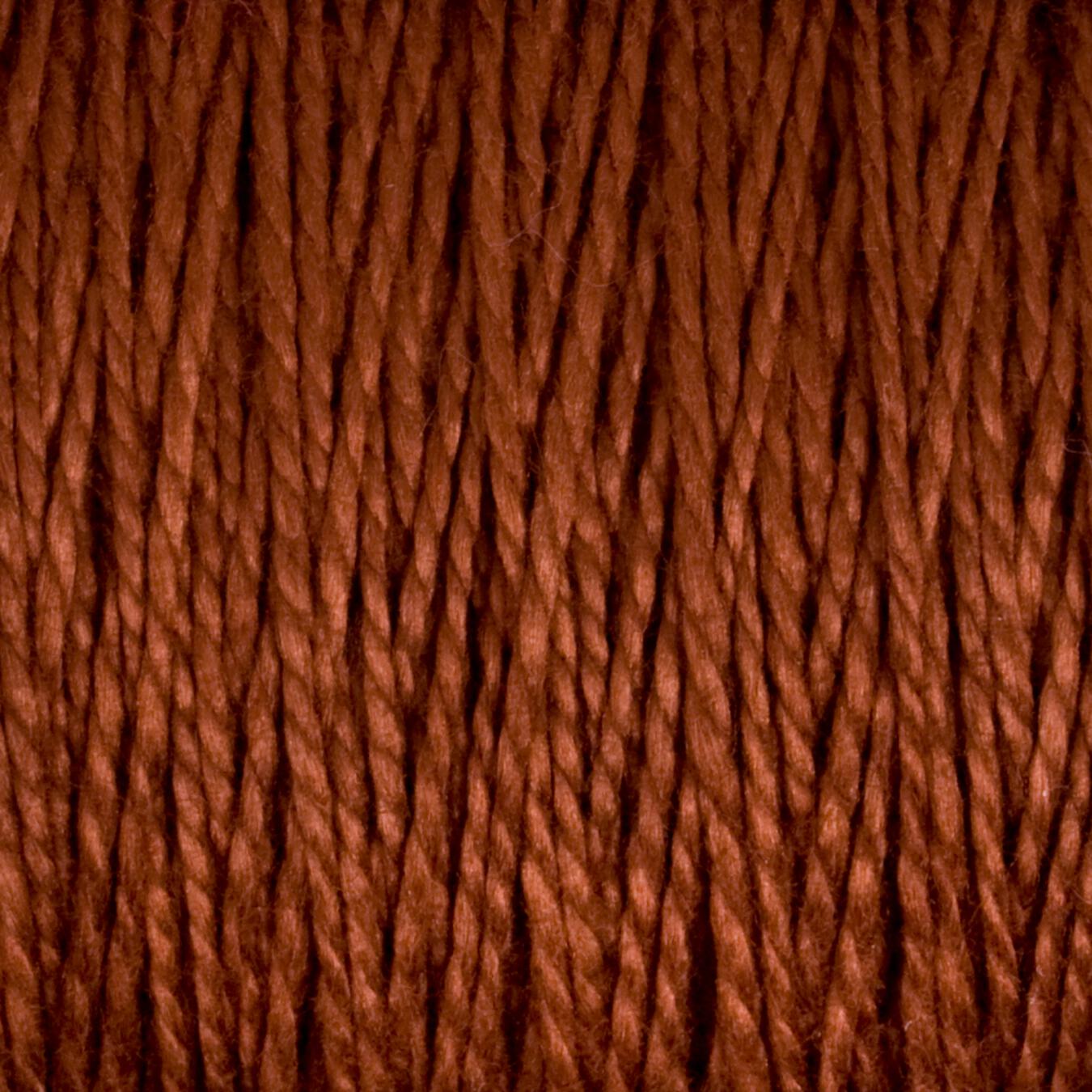 Close-up of Supreme Corp.'s 10/2 Pearl Cotton Yarn in large cone. The fibers are tightly twisted together, showcasing a detailed texture where individual strands interweave to create a thick, cohesive material. The earthy brown hue enhances the versatile yarn with a rich, warm appearance.