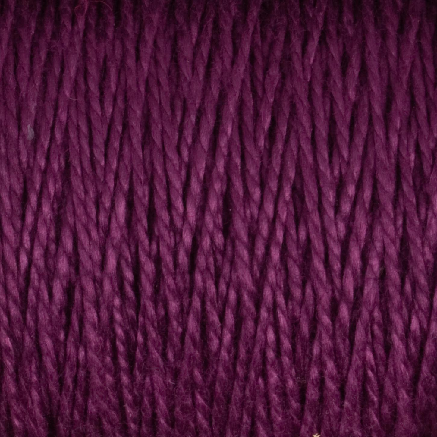 Close-up image of the deep purple 10/2 Pearl Cotton Yarn from Supreme Corp. tightly wound together on a large cone, showcasing the intricate texture of the colorfast fibers.