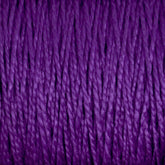 Close-up of strands of deep purple 10/2 Pearl Cotton Yarn by Supreme Corp., tightly wound together to form a textured surface. The versatile yarn fibers exhibit a consistent, smooth twist, creating an intricate pattern of lines and shadows. The color is rich and vibrant, emphasizing the yarn's soft, woolly texture on this large cone.