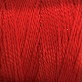 Close-up image of a skein of Supreme Corp.'s 10/2 Pearl Cotton Yarn | Large Cone in red, showcasing the tightly wound fibers and texture. The yarn appears smooth, slightly shiny, and colorfast, making it suitable for versatile knitting or crocheting projects.