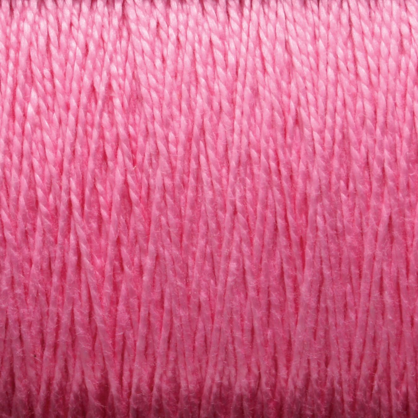 Close-up of a spool of 10/2 Pearl Cotton Yarn | Large Cone by Supreme Corp. The yarn is tightly wound, creating a textured surface. The color is uniform with a soft pink hue that gives it a smooth and delicate appearance. This versatile thread is perfect for various projects, ensuring both beauty and durability.