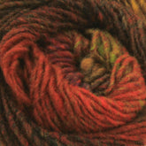 Close-up of a textured ball of Kureyon by Noro handspun yarn, primarily featuring rich red, brown, and green hues. The strands are intricately intertwined, showcasing the various shades and creating a warm, autumnal feel with unique intarsia designs. This exquisite yarn is brought to you by Knitting Fever / Euro Yarns.