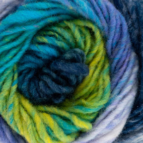 A close-up of a skein of Kureyon by Noro from Knitting Fever / Euro Yarns, showcasing a spiral of fibers in shades of blue, green, teal, and purple. The texture appears soft and fluffy, with gradual color changes blending seamlessly into one another.