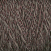 Close-up view of the Block Island Blend | Large Cone yarn with interwoven strands. The yarn, spun and dyed in Maine by Halcyon Yarn, features a mix of earthy tones, including shades of brown and gray, creating a natural and rustic appearance. The soft and slightly fuzzy texture gives it a cozy and warm look.