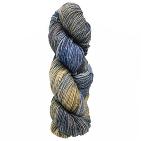 A skein of Malabrigo Rios, a luxurious yarn from Malabrigo Yarn, features variegated shades of blue, gray, yellow, and cream, twisted into a spiral shape.