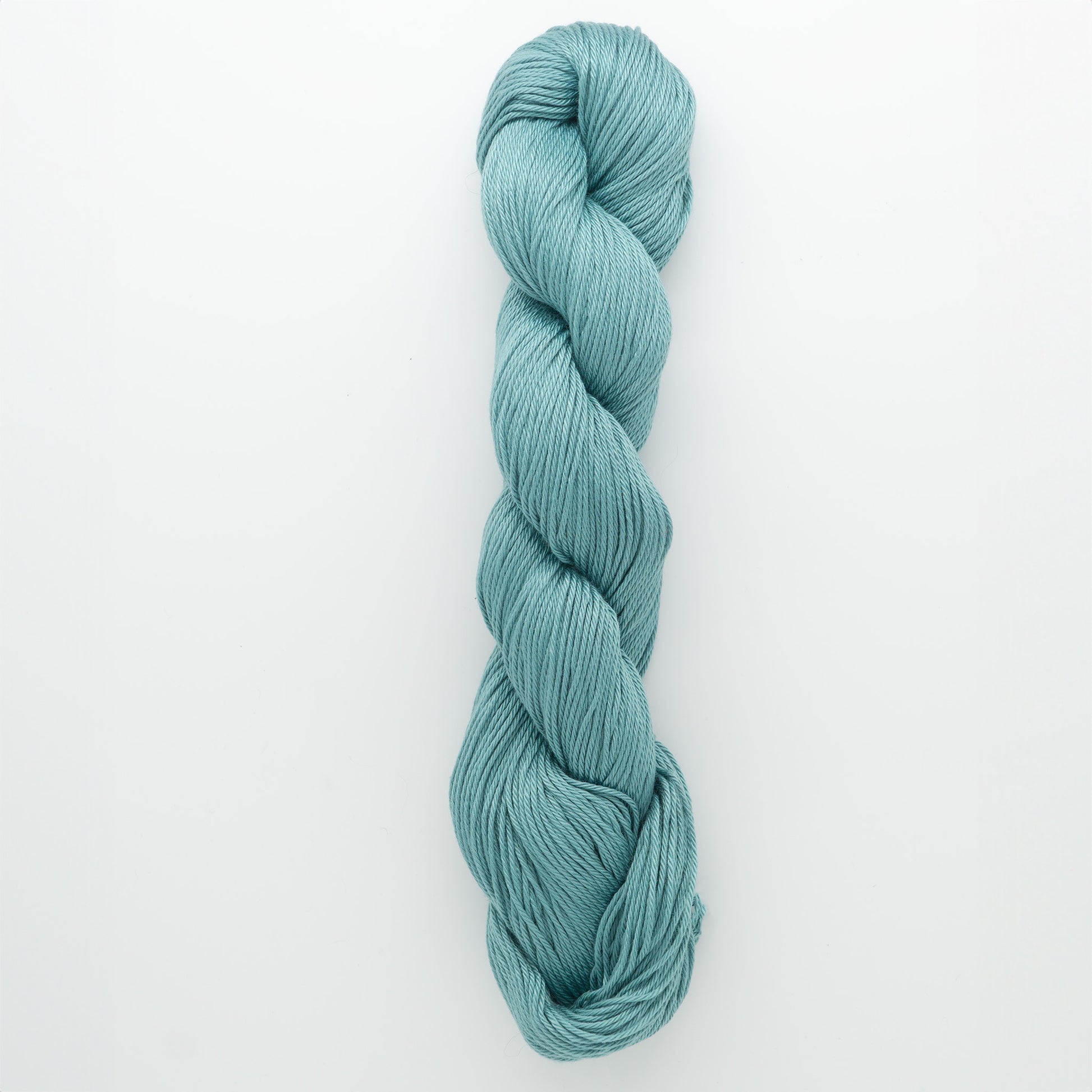 A single skein of Cascade Ultra Pima Cotton Yarn in turquoise, from Cascade Yarns, is neatly twisted into a loop. Made from Peruvian Pima Cotton, this yarn boasts a smooth texture and vibrant blue-green hue, creating a visually appealing and inviting appearance for knitters and crafters against the plain white background.