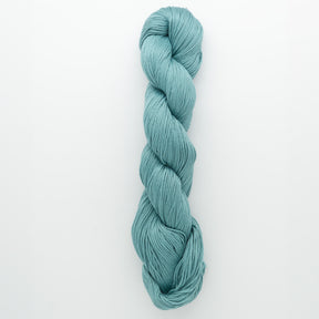 A single skein of Cascade Ultra Pima Cotton Yarn in turquoise, from Cascade Yarns, is neatly twisted into a loop. Made from Peruvian Pima Cotton, this yarn boasts a smooth texture and vibrant blue-green hue, creating a visually appealing and inviting appearance for knitters and crafters against the plain white background.